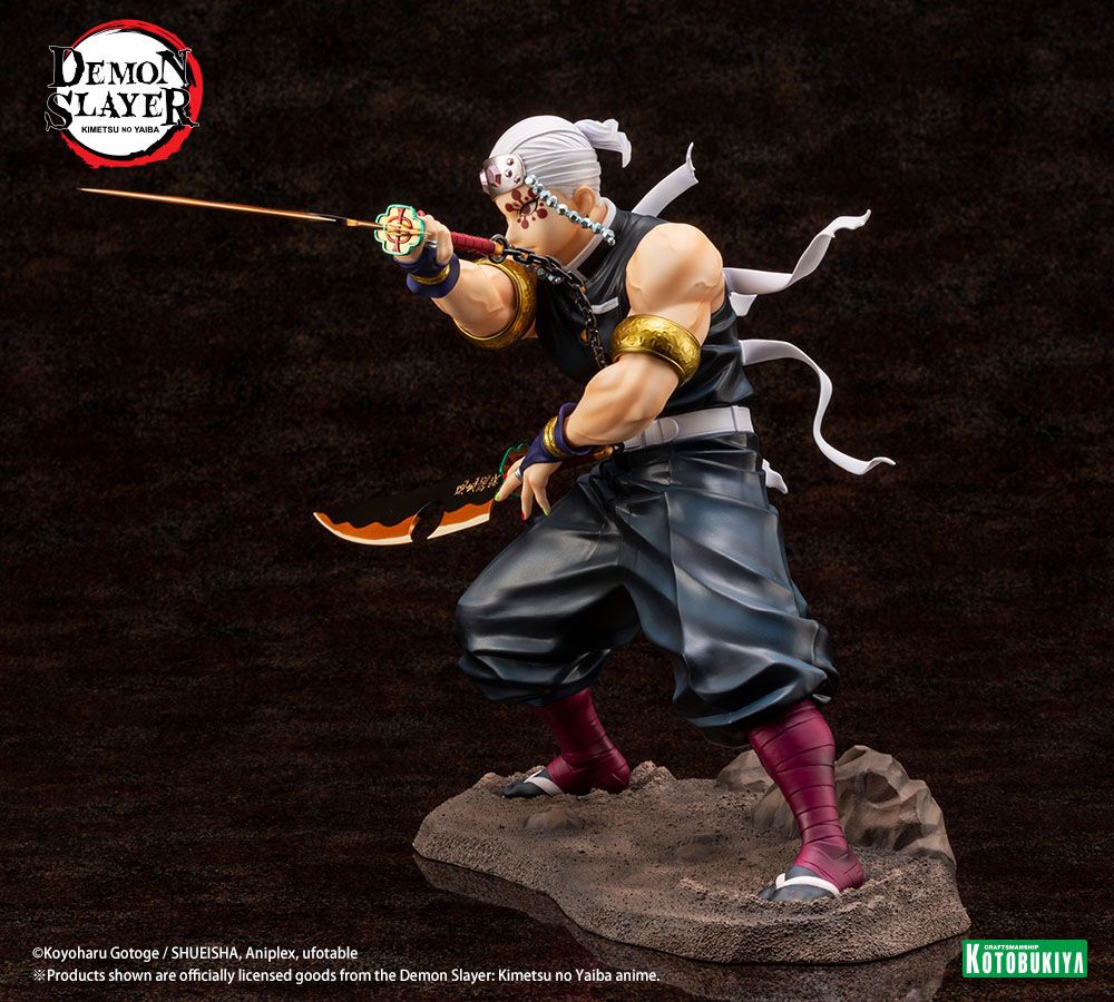 Figurine de Tengen Uzui de Demon Slayer en pose de combat, tenant deux sabres, sur un socle rocheux. Il porte son bandeau orné de pierres précieuses et sa tenue de shinobi sans manches, mettant en valeur sa musculature.