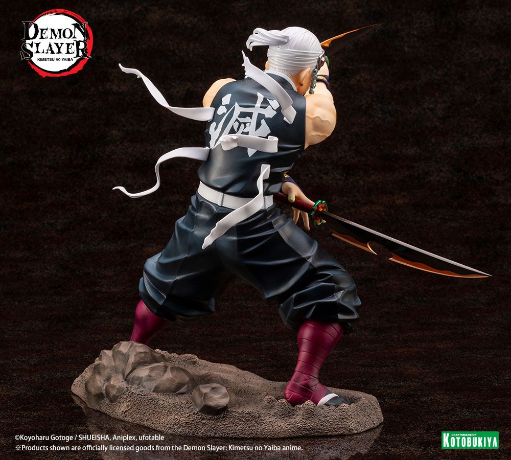 Figurine de Tengen Uzui de Demon Slayer en pose de combat, tenant deux sabres, sur un socle rocheux. Il porte son bandeau orné de pierres précieuses et sa tenue de shinobi sans manches, mettant en valeur sa musculature.