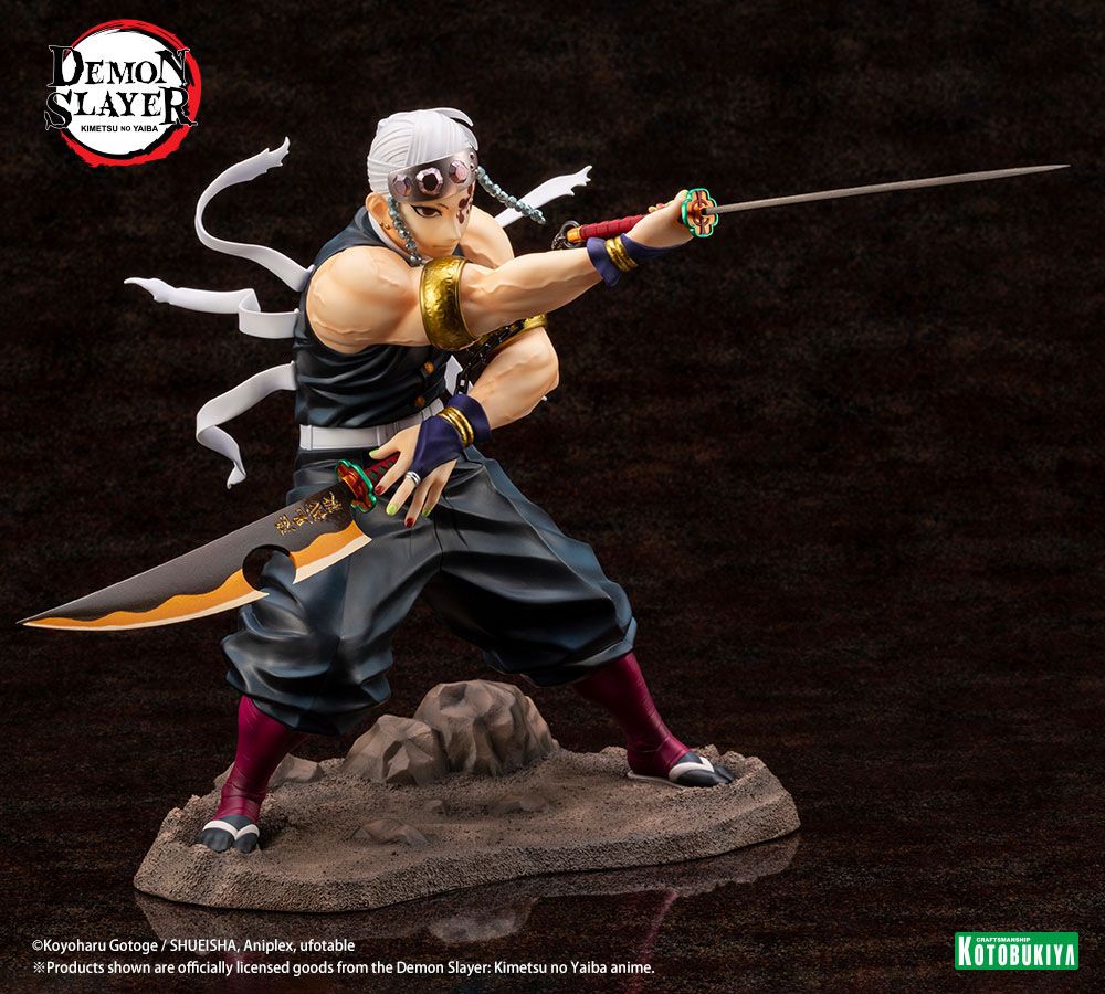 Figurine de Tengen Uzui de Demon Slayer en pose de combat, tenant deux sabres, sur un socle rocheux. Il porte son bandeau orné de pierres précieuses et sa tenue de shinobi sans manches, mettant en valeur sa musculature.