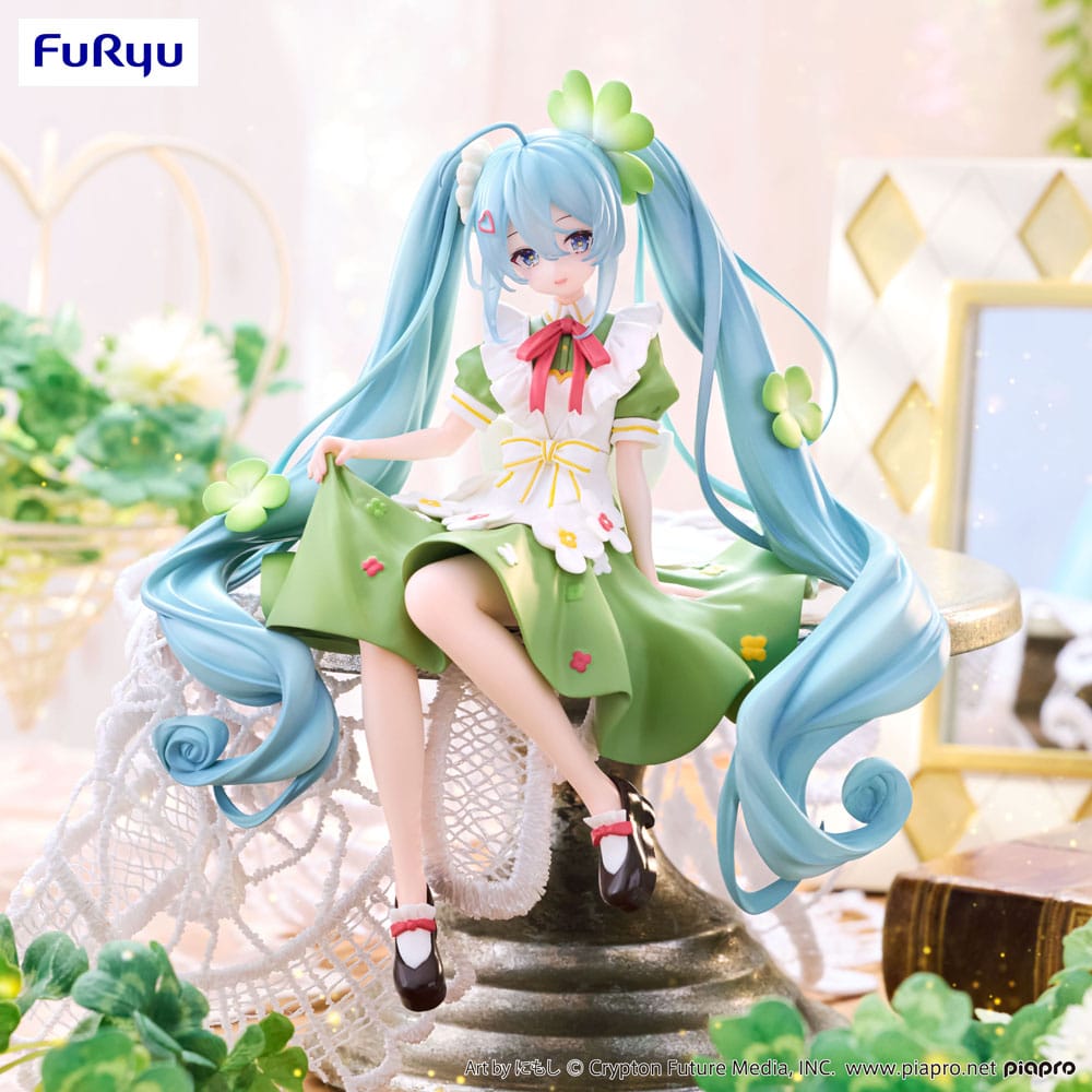 Figurine Hatsune Miku Flower Fairy Clover de 15 cm, assise en tenue verte décorée de trèfles et de fleurs, avec de longues couettes bleu clair et un ruban rouge.