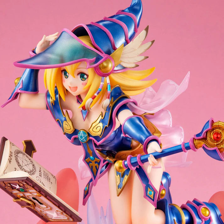 Figurine colorée de Dark Magician Girl de Yu-Gi-Oh!, en lévitation avec un grimoire magique, un sceptre et un socle orné de symboles dorés.