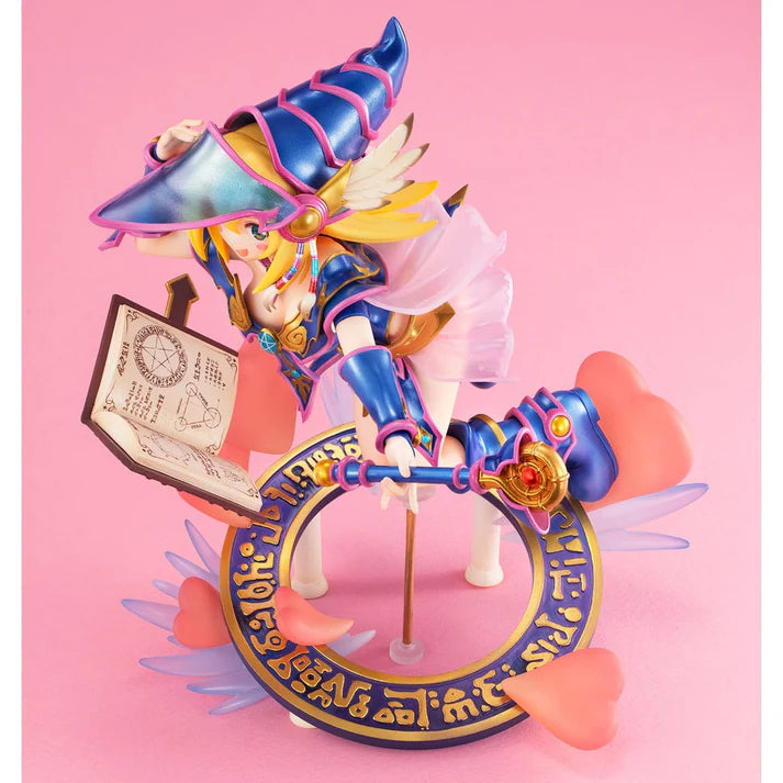 Figurine colorée de Dark Magician Girl de Yu-Gi-Oh!, en lévitation avec un grimoire magique, un sceptre et un socle orné de symboles dorés.