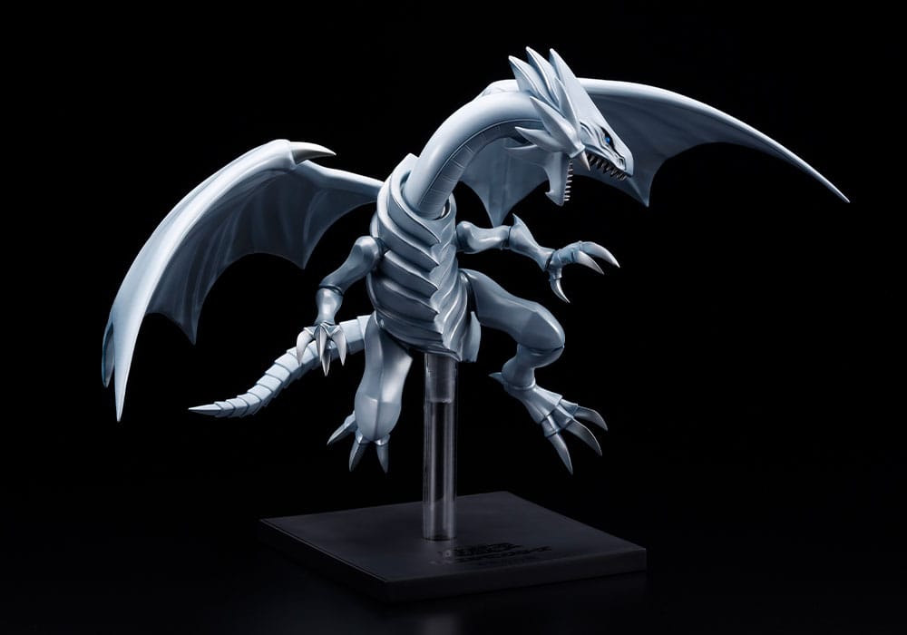Figurine Yu-Gi-Oh! Oshi Works Dragon Blanc aux Yeux Bleus argenté, ailes déployées sur socle d’exposition noir.