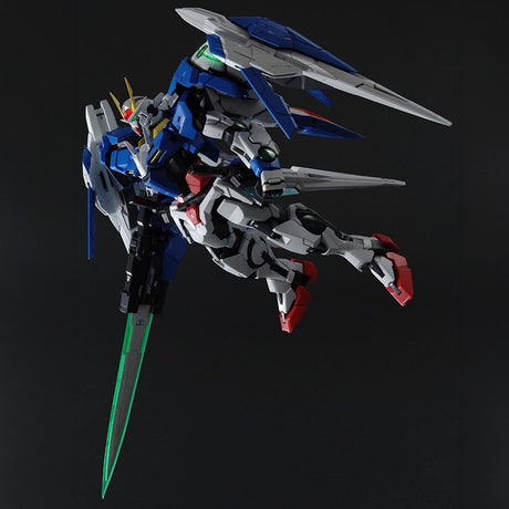 Maquette Gunpla PG 1/60 00 Raiser blanche, bleue et rouge avec équipements dorsaux, armes et boucliers, sur fond blanc.