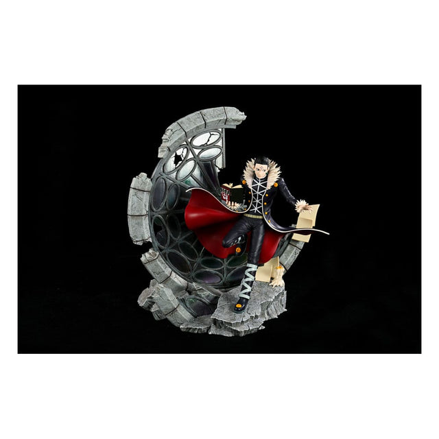 Statue Kuroro Lucilfer 33 cm Hunter x Hunter en édition limitée, posée devant un décor en ruines circulaires.