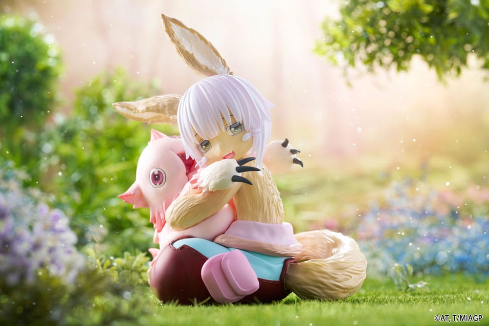 Figurine Nanachi et Mitty assises dans un décor verdoyant issue de Made in Abyss avec une pose tendre et protectrice