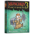 Boîte de l'extension Munchkin 3 – Clerc et (pas) Net de Steve Jackson, illustrée par John Kovalic, représentant un personnage humoristique en tenue de clerc avec livre, bouclier et arme à pointes sur fond vert turquoise.