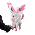 Grande peluche Pokémon Nymphali 60 cm blanche et rose avec rubans bleus et roses, grands yeux bleus et expression joyeuse.