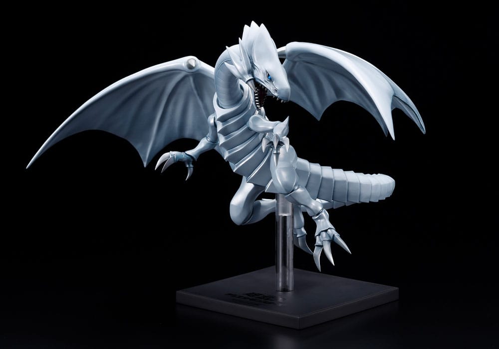 Figurine Yu-Gi-Oh! Oshi Works Dragon Blanc aux Yeux Bleus argenté, ailes déployées sur socle d’exposition noir.