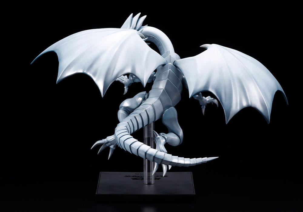 Figurine Yu-Gi-Oh! Oshi Works Dragon Blanc aux Yeux Bleus argenté, ailes déployées sur socle d’exposition noir.